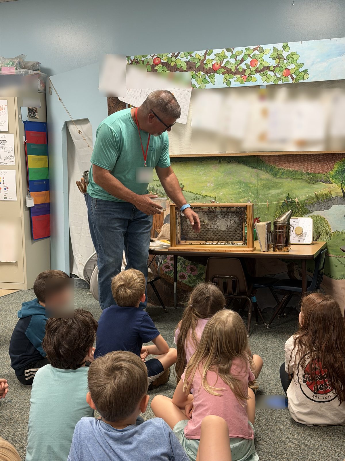 Beekeeping demonstration in a classroom with identifying details blurred